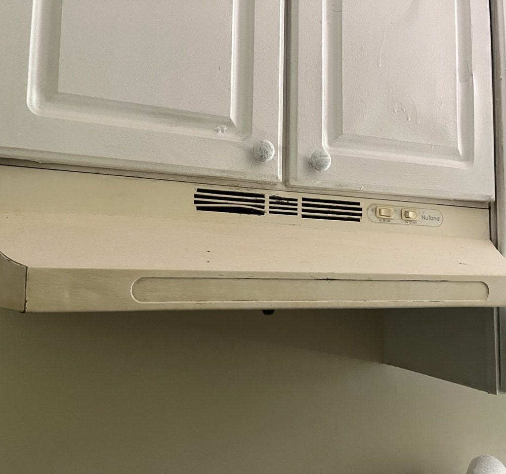 Old kitchen range hood above cabinets