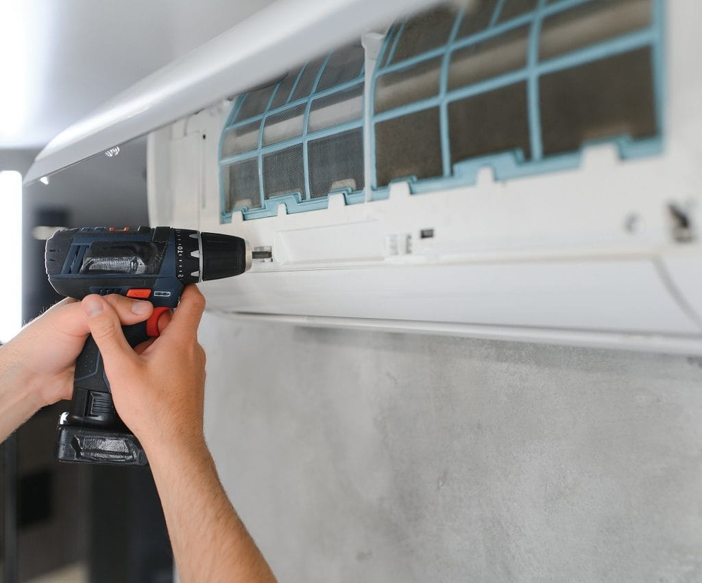 AC installation Charlotte NC technician installing air conditioner in local home.