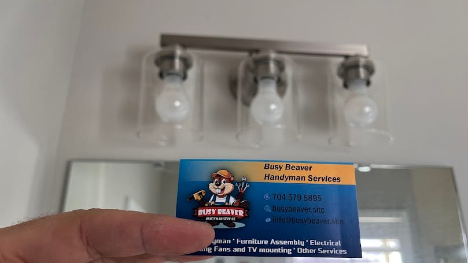 Local handyman from Busy Beaver Handyman Services performing electrical repair in a Charlotte NC home, replacing a wall switch