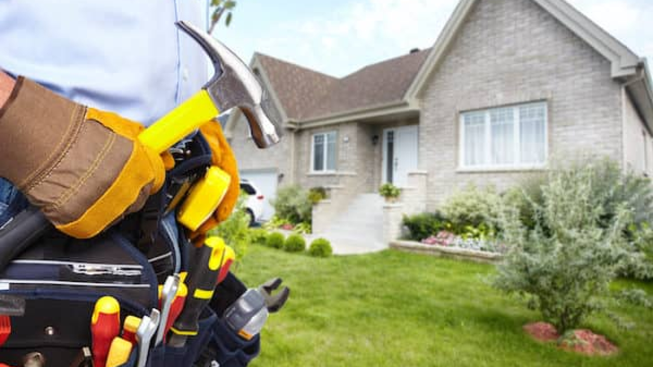 Handyman with tools outside a house