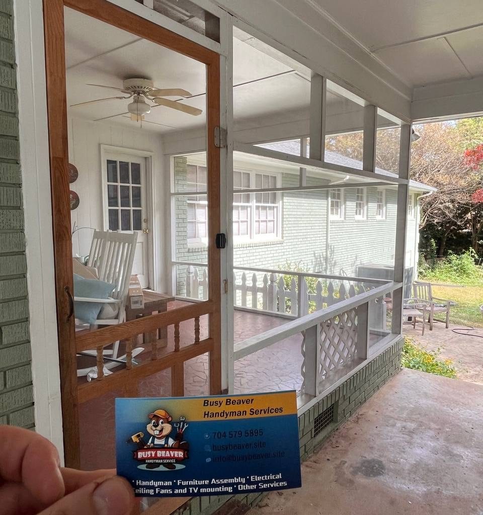 Busy Beaver Handyman Services business card in front of a custom-fitted screen door on a Charlotte porch.